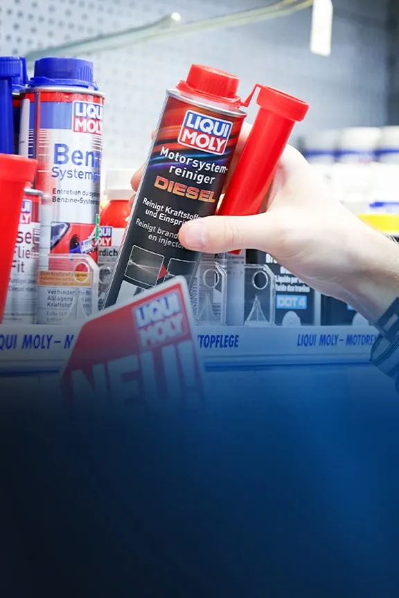 Hand greift im Ladenregal nach Liqui Moly Dieselsystemreiniger, davor Schild „NEU!“.